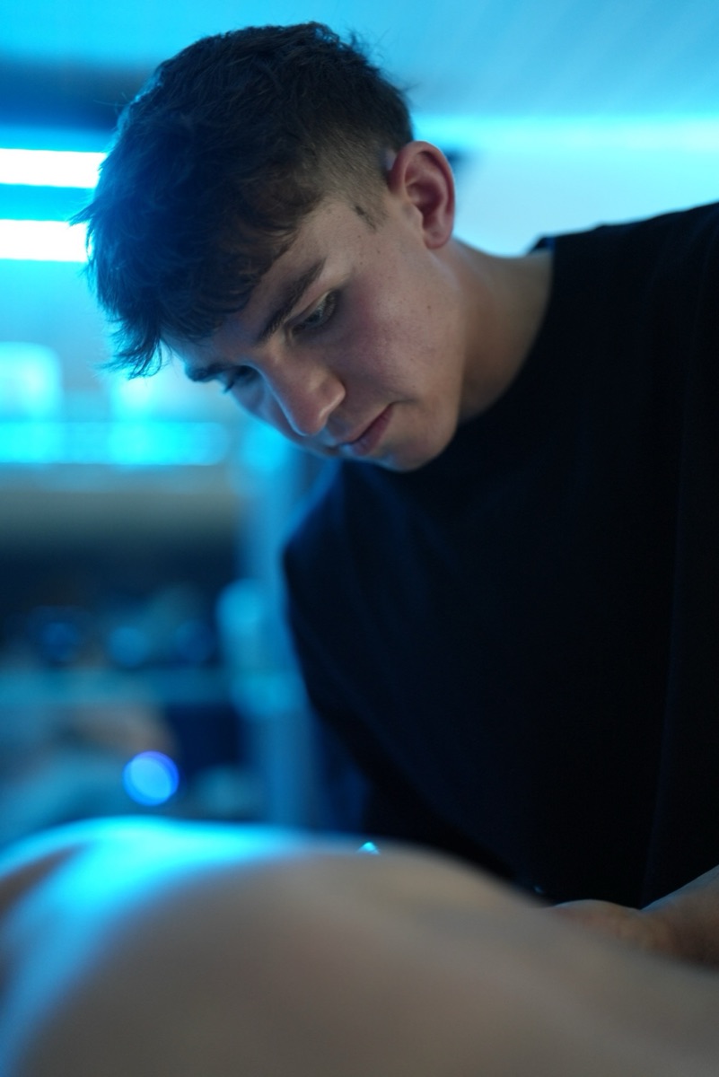 Harry Hearsum giving a deep tissue sports massage in the blue-lit treatment room in Treeton